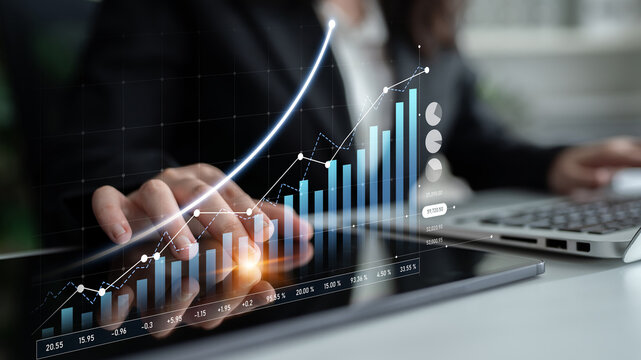 A business professional engages with financial data on a digital tablet, highlighting growth and statistics through interactive visuals in a modern workspace. Scalp - Powered by Adobe