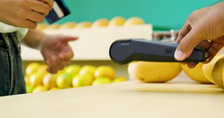 Asian woman tapping blue credit card on payment terminal while buying mangoes at grocery store representing digital transaction in modern retail lifestyle with fresh fruit health-conscious behavior - Powered by Adobe