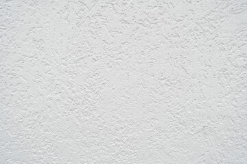 The wall finish in the image is called decorative textured light grey plaster. This is a general term for a wide range of finishes that impart a three-dimensional texture to a surface.
