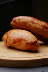 Freshly baked bread rolls on wooden board