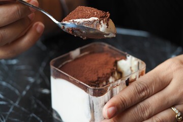 Someone is savoring a delicious dessert with rich chocolate and cream