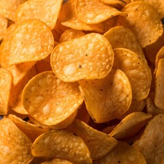Fototapeta premium A pile of seasoned potato chips, showcasing their irregular shapes and savory seasoning, a popular and satisfying snack choice