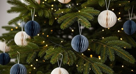 Close-up of a festive Christmas tree adorned with warm lights and elegant navy blue and cream paper globe ornaments.