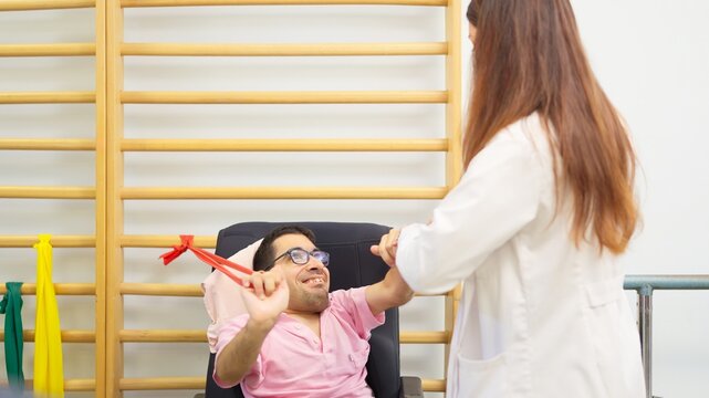 Man with physical disability doing physical therapy with therapist