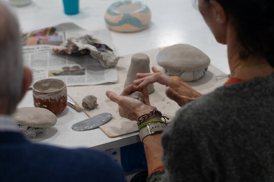 Hands modeling clay shaping pottery in workshop