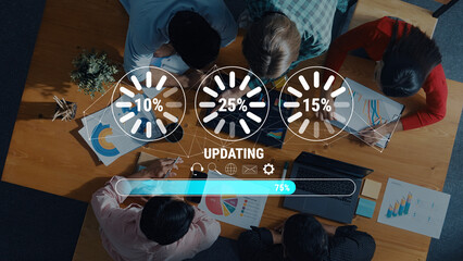 Aerial view of a diverse team engaged in collaborative work in an office. Progress indicators showcase project updates, highlighting teamwork and creativity in a productive environment. Trope