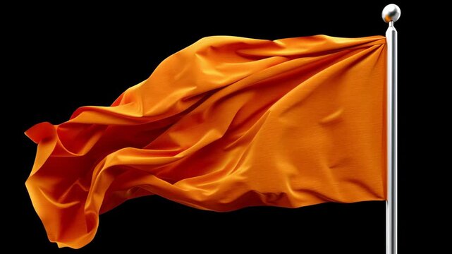 Large orange flag is blowing in the wind. The flag is on a pole