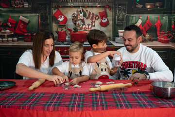 Family baking christmas cookies together in festive kitchen