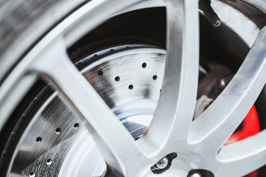 Closeup of drilled performance disc brake rotor on car