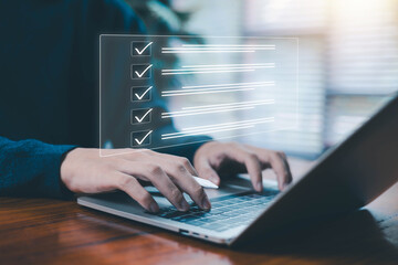 Hands typing on laptop with glowing digital checklist interface symbolizing task management, productivity workflow project planning, and modern digital organization tools for efficient work processes.