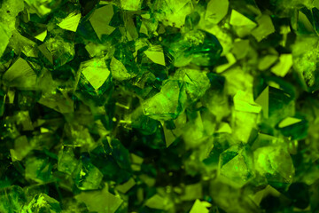 Green crystal mineral stone. Gems. Mineral crystals in the natural environment. Texture of precious and semiprecious stones. Seamless background with copy space colored shiny surface of precious stone