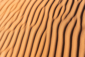 Desert sand dune patterns creating abstract ripple texture in oman