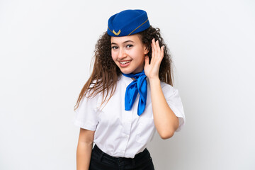Airplane stewardess Arab woman isolated on white background listening to something by putting hand on the ear
