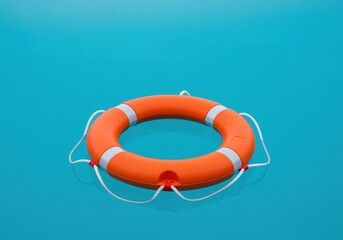 Pristine orange lifebuoy floating calmly on a vibrant turquoise water surface.