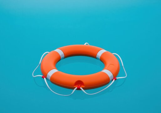 Pristine orange lifebuoy floating calmly on a vibrant turquoise water surface.