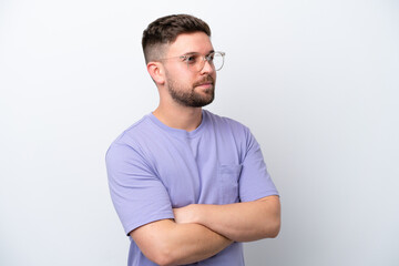 Young caucasian man isolated on white background keeping the arms crossed