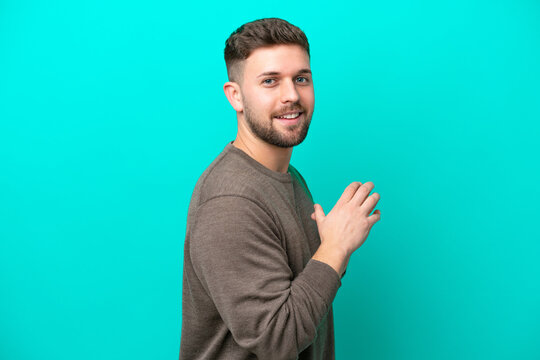 Young caucasian man isolated on blue background scheming something