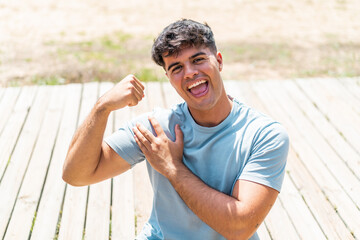 Young hispanic man at outdoors doing strong gesture