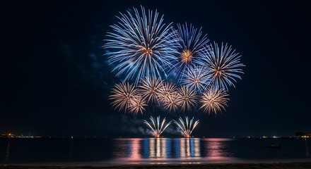 Blue and gold fireworks explode over water night explosion