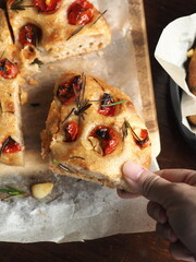 taking a piece of focaccia bread