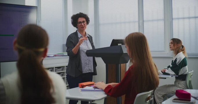 Female Educator in Computer Programming Class Presents Software Code on Smartboard, Engaging Students in Discussion. Concept STEM Education, Interactive Learning, and Innovation in Teaching Methods.