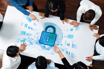 A group of professionals collaborates around a table, analyzing digital security strategies with...