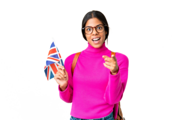 Young African American woman holding an United Kingdom flag over isolated chroma key background surprised and pointing front