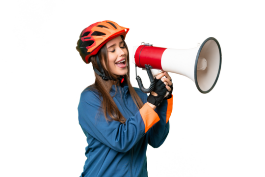 Young cyclist woman over isolated chroma key background shouting through a megaphone