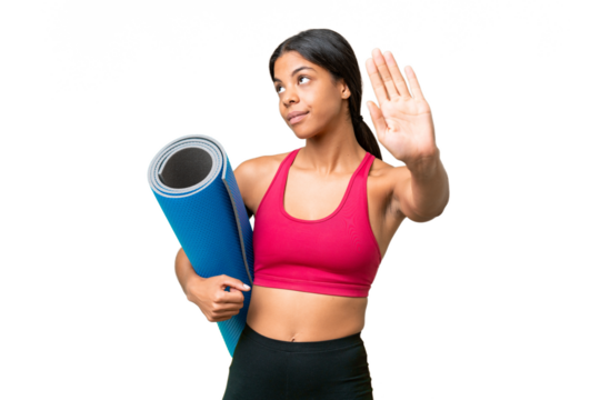 Young sport African American woman going to yoga classes while holding a mat over isolated background making stop gesture and disappointed