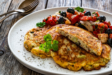 Vegetable pancakes with fresh salad on wooden table
