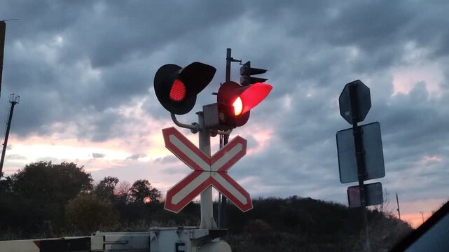 Working semaphore at a railway crossing, prohibiting entry, against the backdrop of the evening sky
