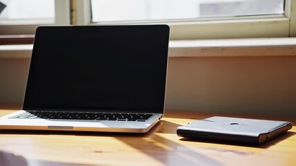Close up of laptop on wooden desk with natural light