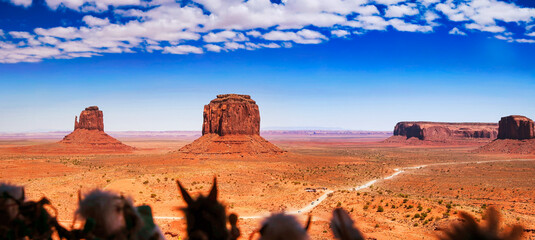 Scenic Monument Valley with iconic red rock formations and arid terrain during summer season