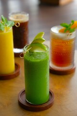 A glass of green juice on the table. Healthy drink, fruit and vegetables juice for detox. Jus buah dan sayur