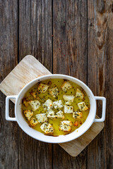 Baked feta cheese in baking dish on wooden table. Top view	