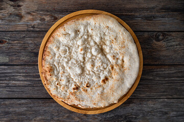 Plain circle pizza on wooden table. Top view