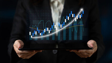 A business professional displays a tablet showcasing a financial growth graph, emphasizing investment success and the role of digital technology in modern corporate environments. Impute