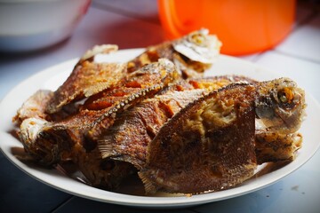 Crispy Fried Tilapia Fish on a White Plate.