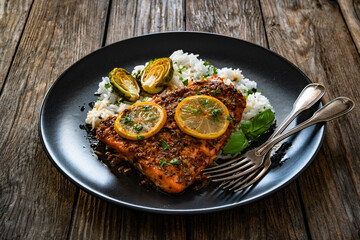 Baked salmon with white rice on wooden table