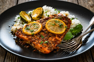 Baked salmon with white rice on wooden table