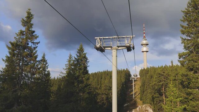 Bottom view of mountain lift and a tower Snezhanka on one of the Rhodope mountains in cloudy weather