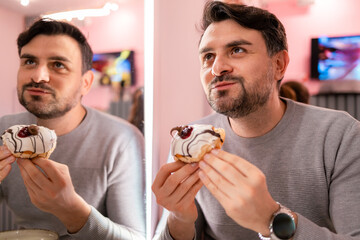 Delighted man enjoys a donut in a vibrant cafe setting during an afternoon gathering