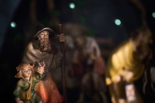 A shepherd with a child goes to the stable to see baby Jesus. A scene from a Christmas nativity scene. Vintage style.