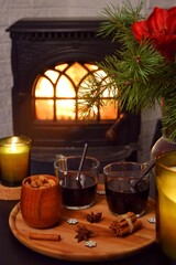 Two mugs of delicious mulled wine by the fireplace.