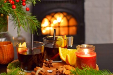 Two mugs of delicious mulled wine by the fireplace.
