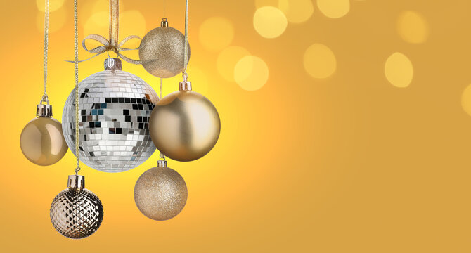 Merry Christmas and Happy Holidays greeting card. Shiny disco ball and festive ornaments on golden background with bokeh lights. Banner design with space for text - Powered by Adobe