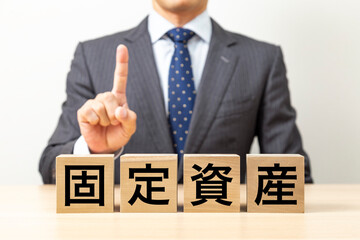「固定資産」と書かれたブロックとビジネスマン