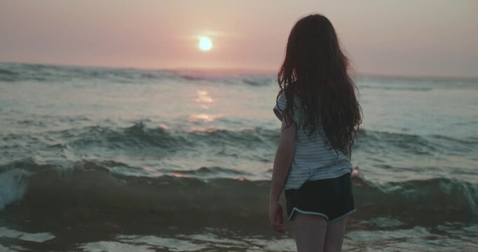 Young girl having fun playing at the beach at sunset; Melbourne, Victoria, Australia