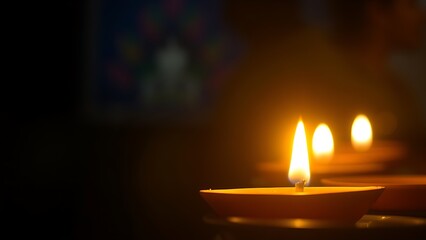 Golden diya glowing in darkness, symbolizing tradition and festive spirit in Indian culture.