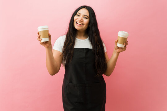 Cheerful barista offering coffee takeaway cups in a studio - Powered by Adobe